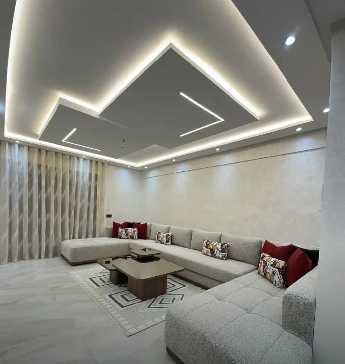 Salon moderne gris chiné sous un plafond lumineux